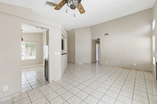 an empty room with ceiling fan and window