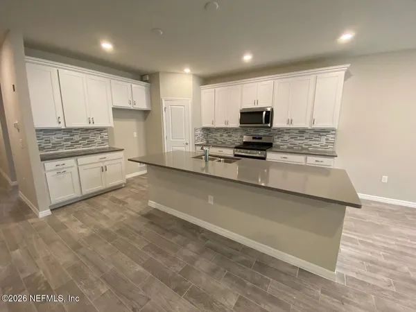 a kitchen with stainless steel appliances granite countertop a stove a sink and a refrigerator