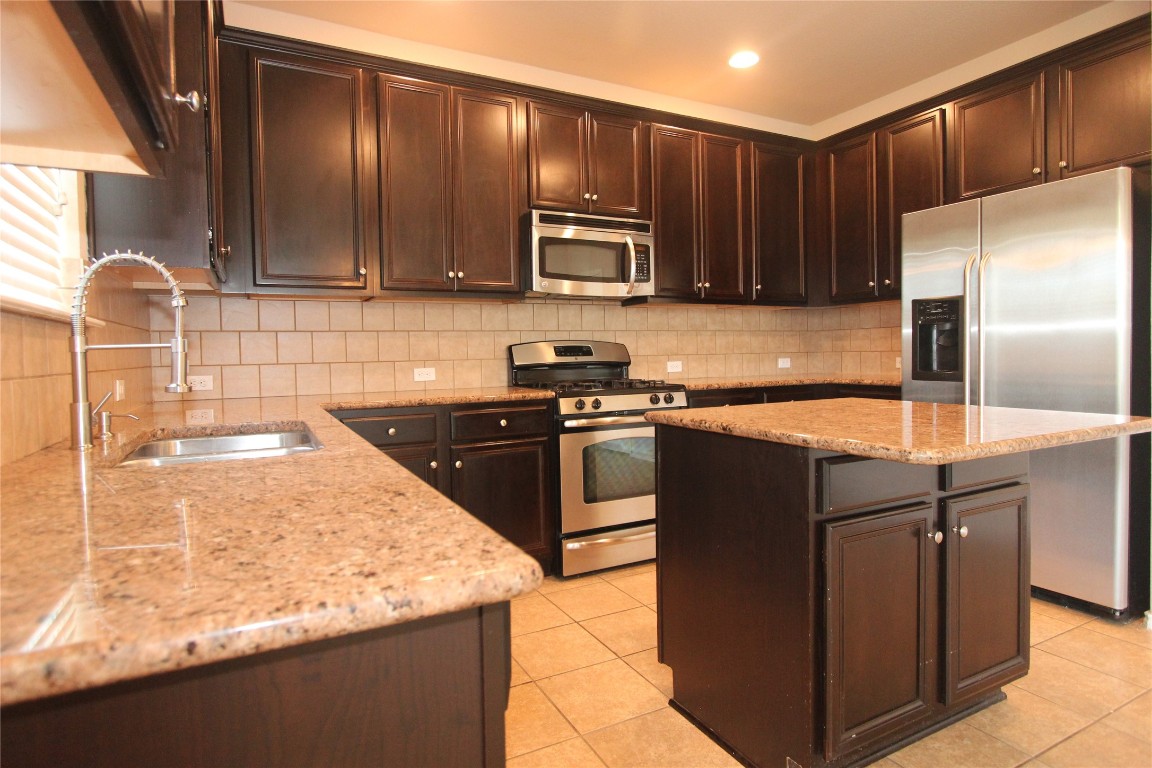 14225 Canyon Trail Austin, TX 78717 - Photo 1 of 1 a kitchen with kitchen island granite countertop stainless steel appliances and wooden cabinets