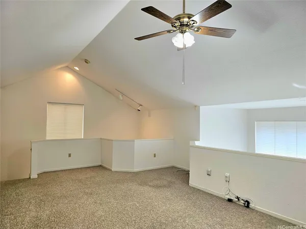an empty room with windows and fan
