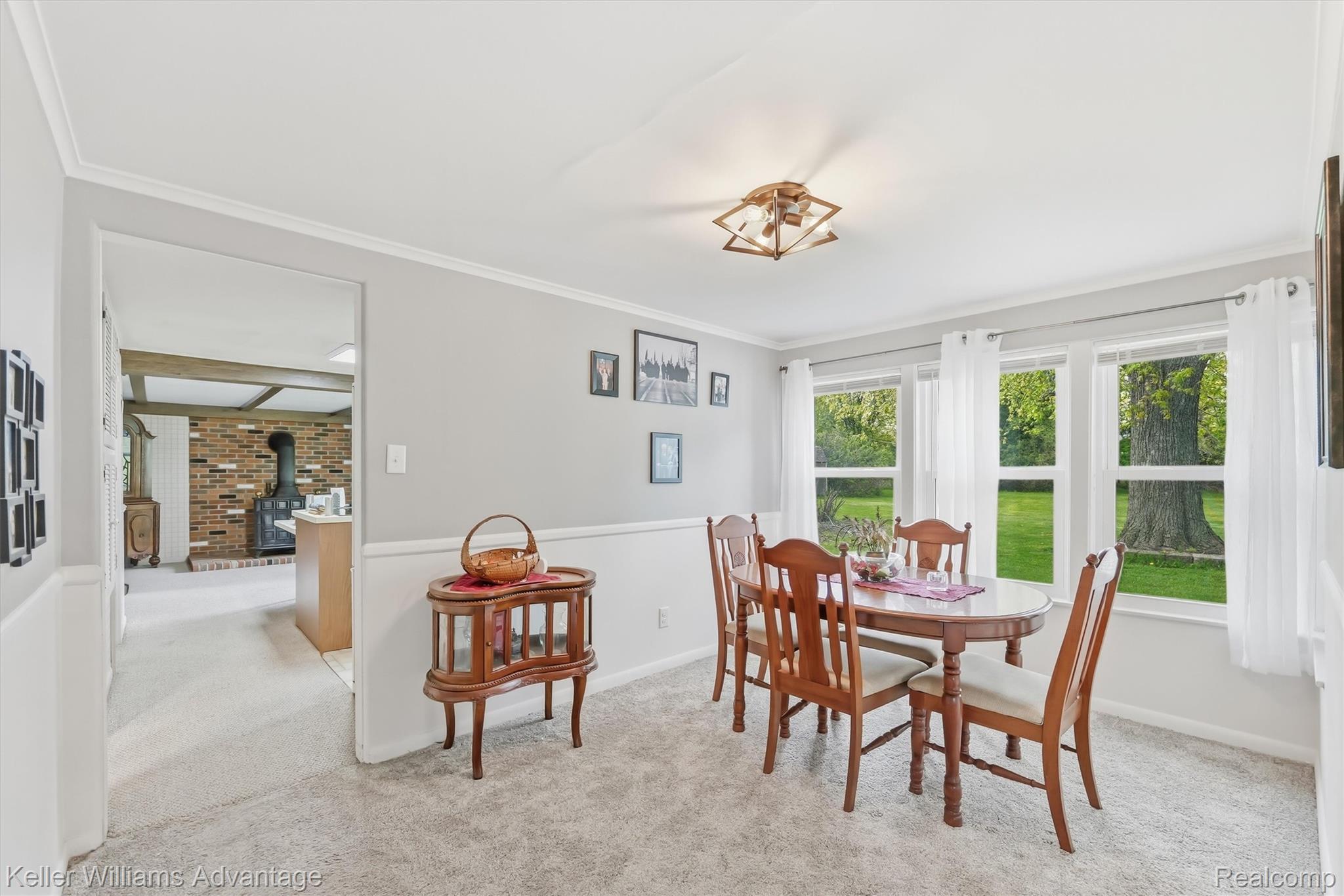 6595 Bray Road Vassar, MI 48768 - Photo 16 of 64 Dining room featuring light colored carpet, a wood stove, and ornamental molding