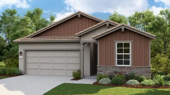 a view of a house with a yard plants and large tree