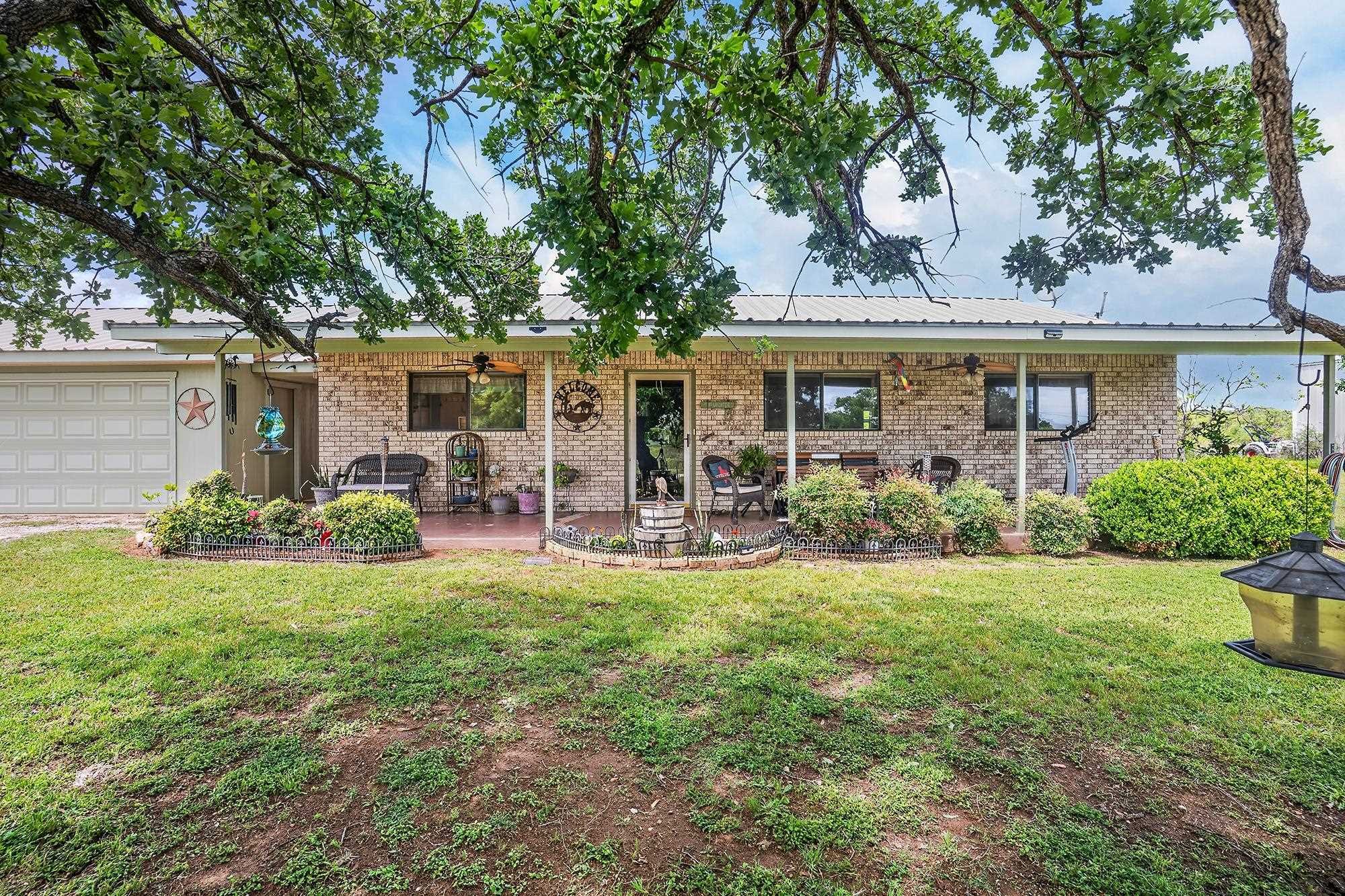 10465 Ranch To Market 1431 Buchanan Dam, TX 78609 - Photo 2 of 29 a view of a house with backyard sitting area and garden