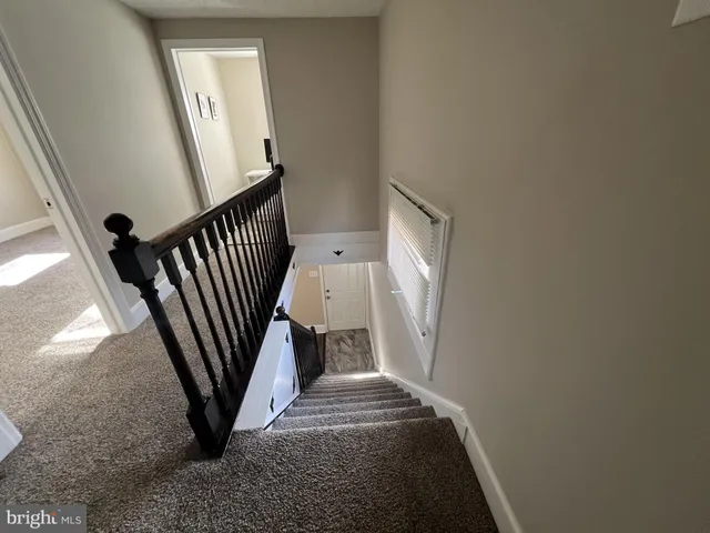 a view of staircase with railing and white walls
