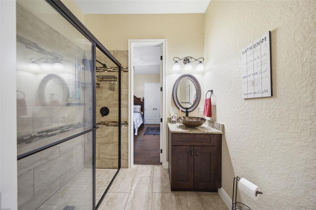 13429 Montevista Road Clermont, FL 34711 - Photo 47 of 89 a bathroom with a sink a mirror and shower