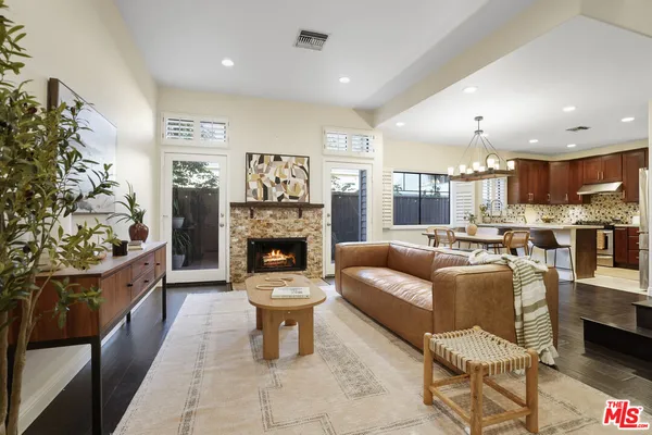 a living room with furniture a fireplace and a kitchen view