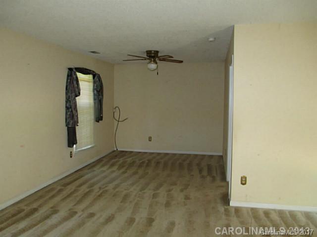 8611 Waterrock Road Charlotte, NC 28214 - Photo 3 of 8 a view of a small space with wooden floor and a ceiling fan