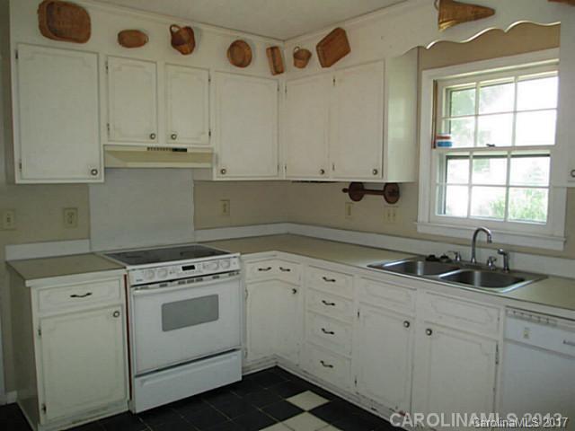 8611 Waterrock Road Charlotte, NC 28214 - Photo 4 of 8 a kitchen with granite countertop white cabinets and white appliances