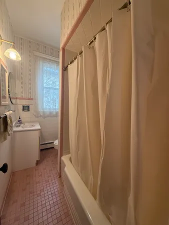 a bathroom with a sink a toilet a mirror and a tub