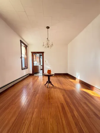a living room with hardwood floor and a window