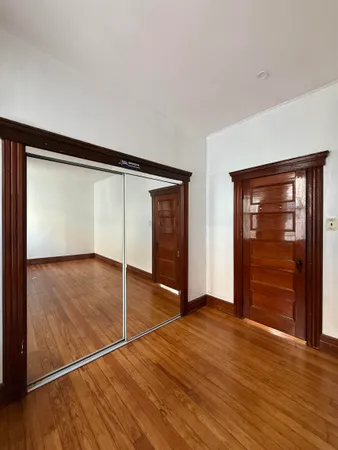 an empty room with wooden floor and closet