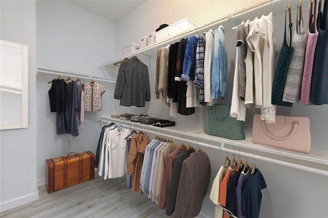 a view of walk in closet with clothes and shoes