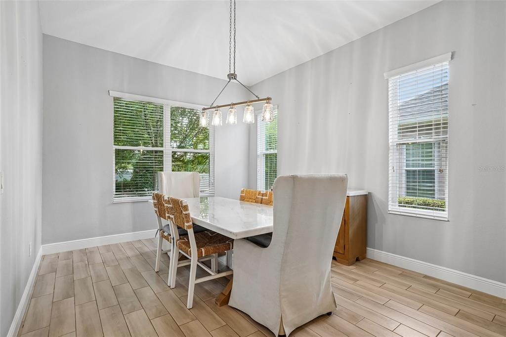 10339 Addison Shore Way Oxford, FL 34484 - Photo 31 of 54 a dining room with wooden floor and a window