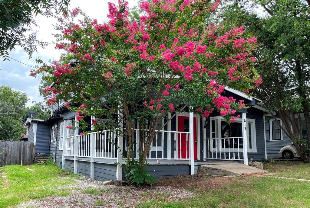 a front view of a house with a tree