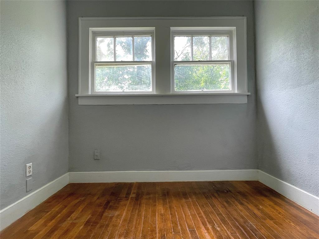 613 Northwest 5th Street Mineral Wells, TX 76067 - Photo 21 of 34 an empty room with wooden floor and windows