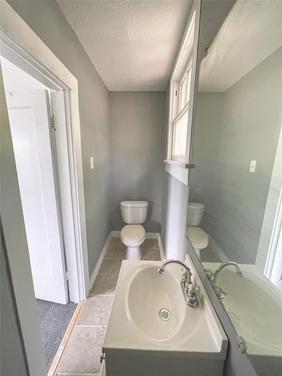 613 Northwest 5th Street Mineral Wells, TX 76067 - Photo 30 of 34 a bathroom with a sink and mirror with toilet