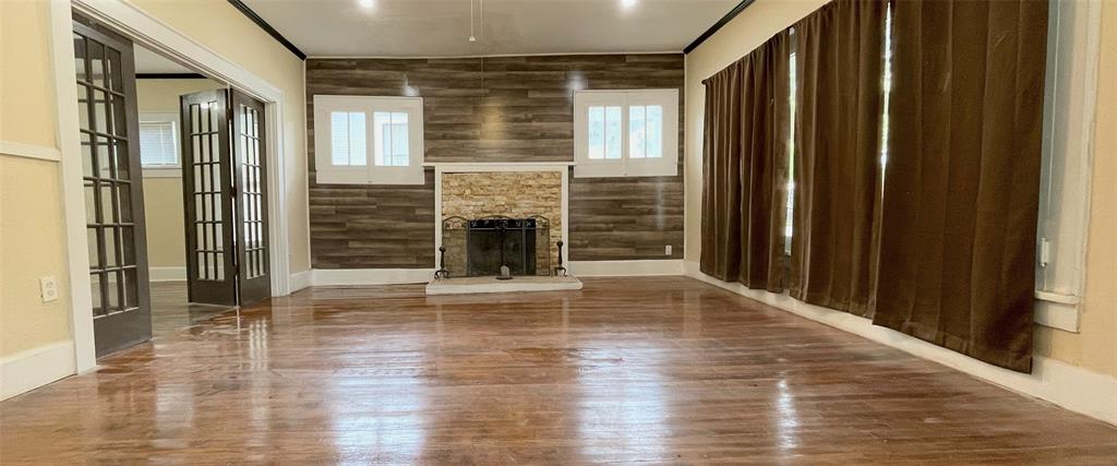 613 Northwest 5th Street Mineral Wells, TX 76067 - Photo 6 of 34 a view of an empty room with wooden floor and a window