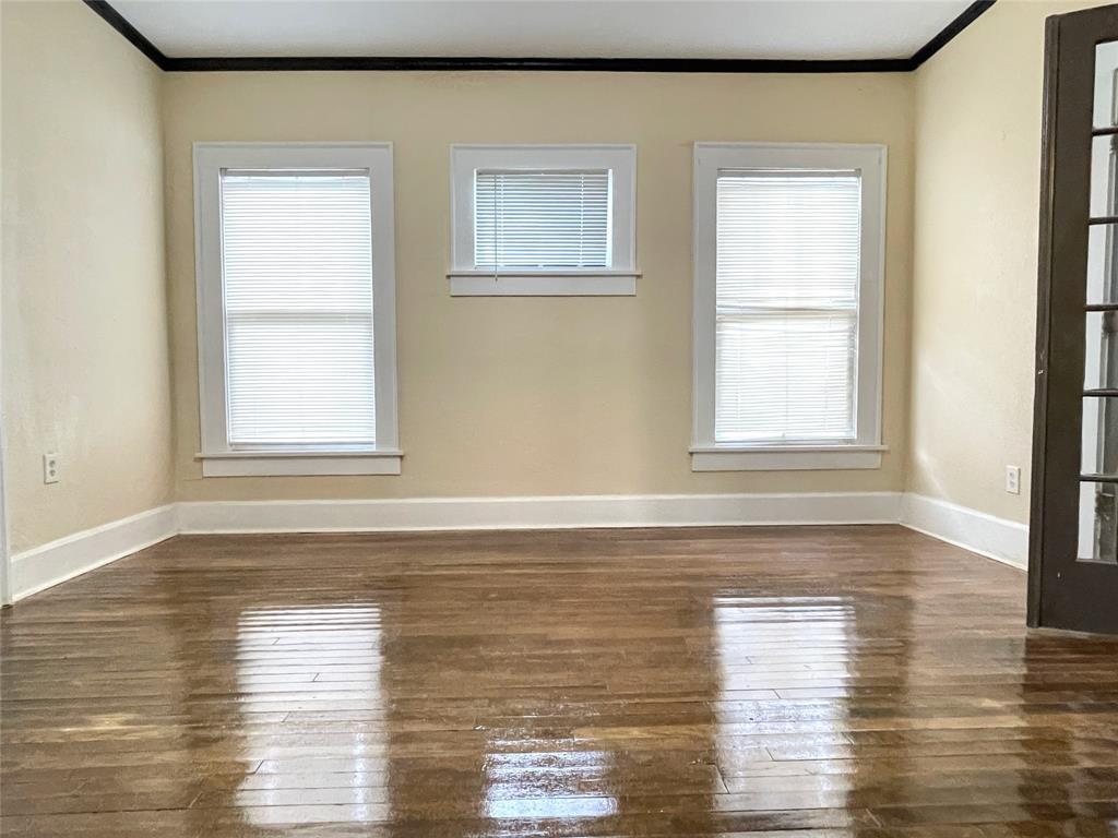 613 Northwest 5th Street Mineral Wells, TX 76067 - Photo 9 of 34 a view of an empty room with wooden floor and a window