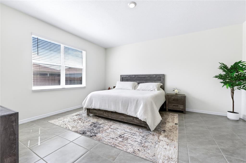 4975 Northwest 39th Loop Ocala, FL 34482 - Photo 19 of 76 a bedroom with a bed lamp and a potted plant