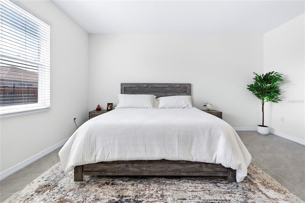 4975 Northwest 39th Loop Ocala, FL 34482 - Photo 20 of 76 a bedroom with a bed and a potted plant
