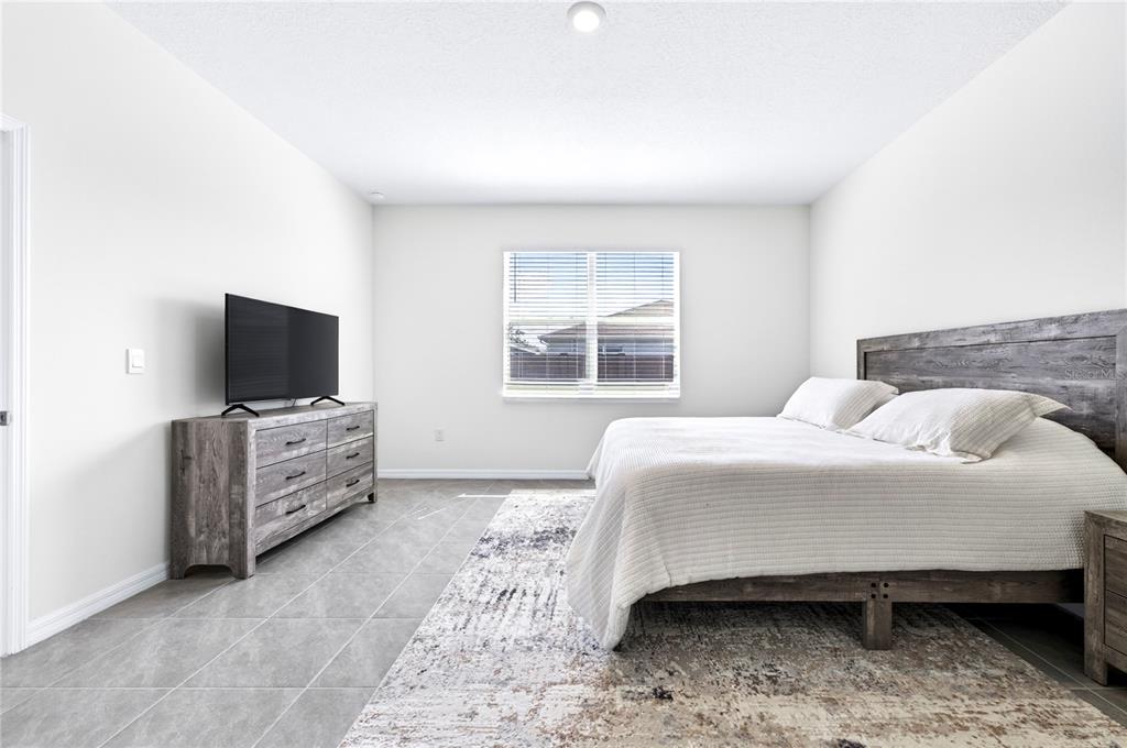 4975 Northwest 39th Loop Ocala, FL 34482 - Photo 21 of 76 a bedroom with a bed and flat screen tv