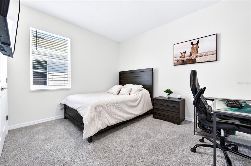 4975 Northwest 39th Loop Ocala, FL 34482 - Photo 33 of 76 a bedroom with a bed a desk and chair next to a window