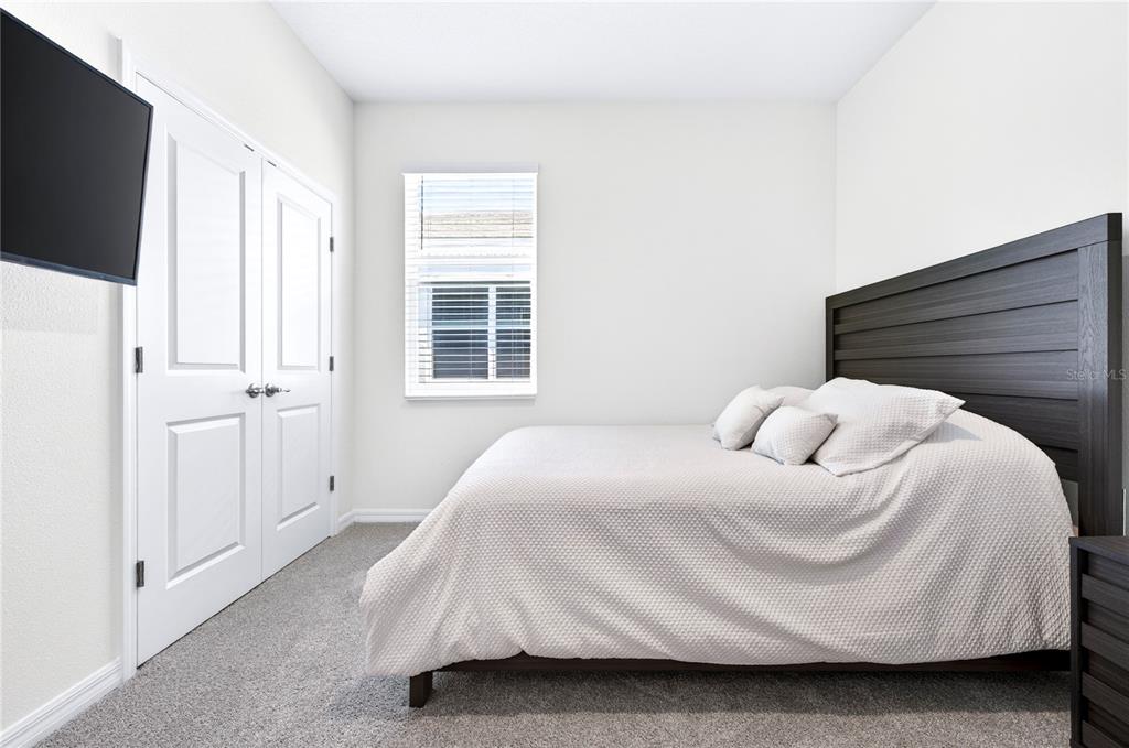 4975 Northwest 39th Loop Ocala, FL 34482 - Photo 34 of 76 a bedroom with a bed and a flat tv screen