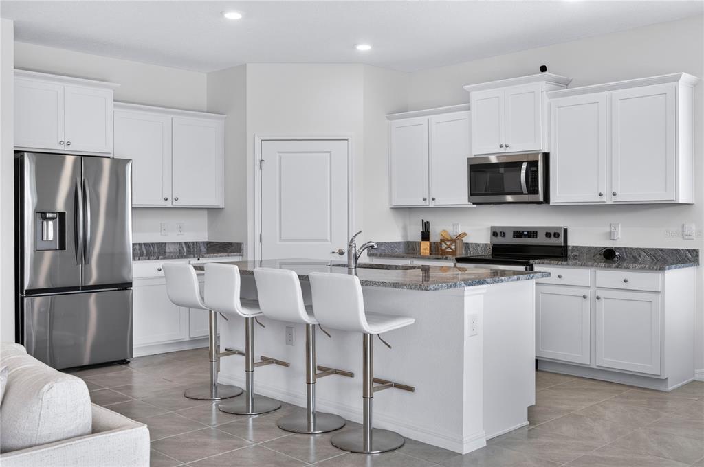 4975 Northwest 39th Loop Ocala, FL 34482 - Photo 7 of 76 a kitchen with stainless steel appliances granite countertop a refrigerator and a stove top oven