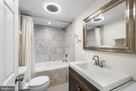 a bathroom with a sink mirror toilet and bathtub