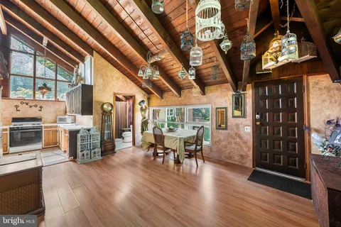 a view of a dining room with furniture a chandelier and wooden floor