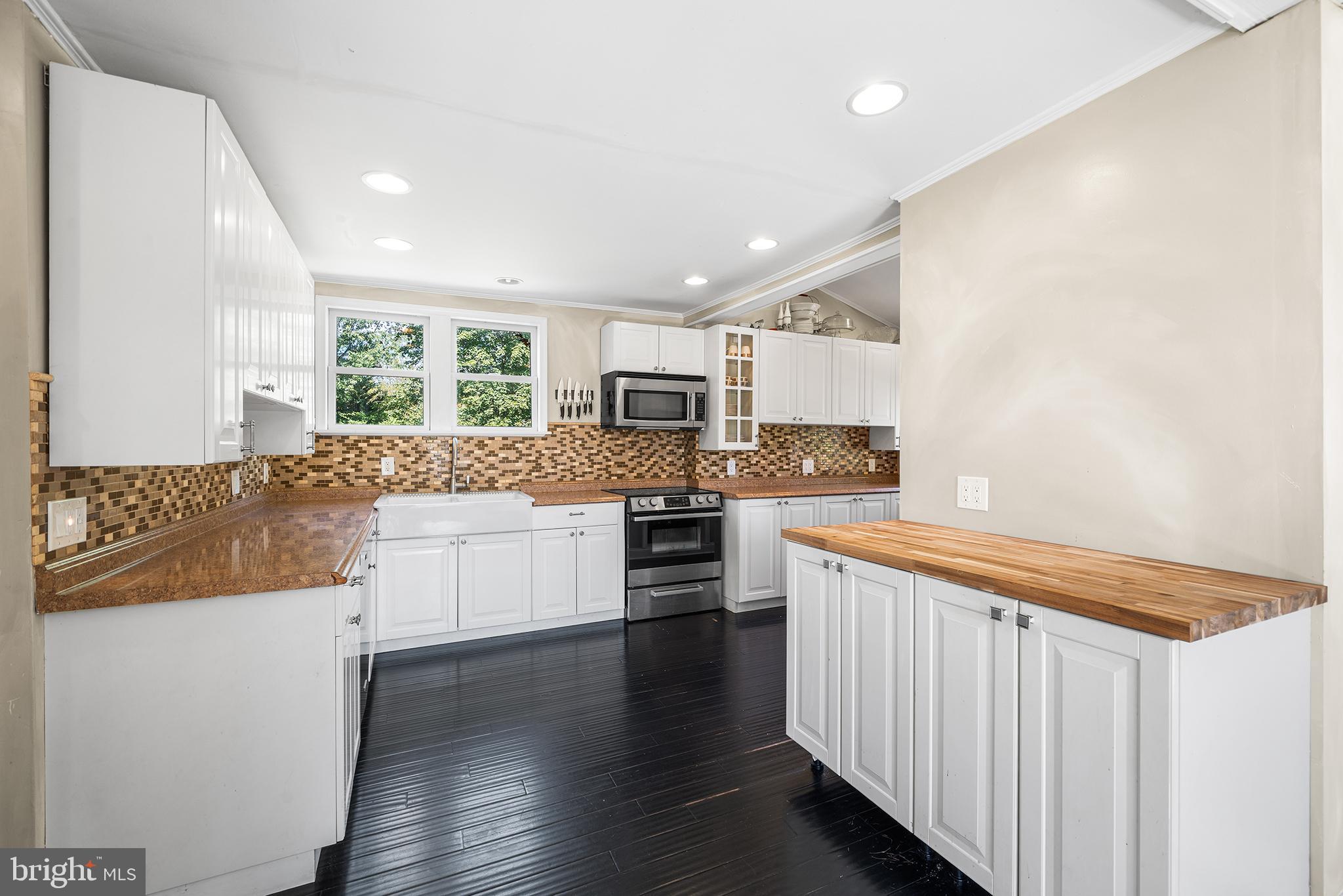 787 North Lewis Road Royersford, PA 19468 - Photo 6 of 53 a kitchen with stainless steel appliances kitchen island granite countertop a stove a sink and white cabinets with wooden floor