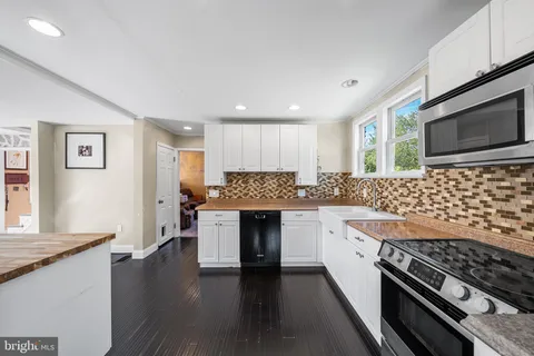 a kitchen with stainless steel appliances kitchen island granite countertop a stove and cabinets