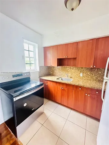 a kitchen with granite countertop a stove a sink and a microwave