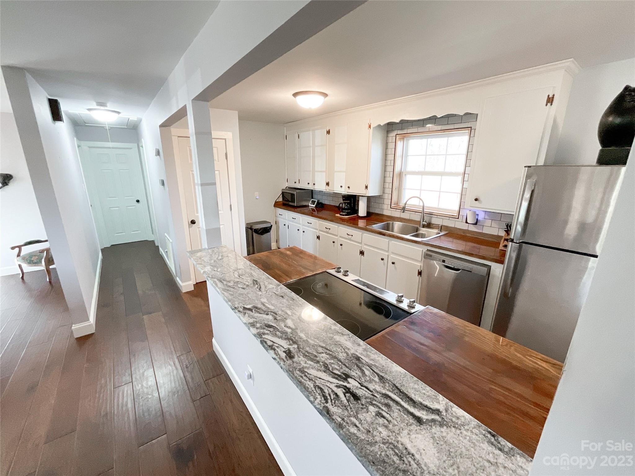 4423 Austin Road Monroe, NC 28112 - Photo 6 of 31 a kitchen with stainless steel appliances granite countertop a refrigerator a sink dishwasher a stove and white countertops with wooden floor