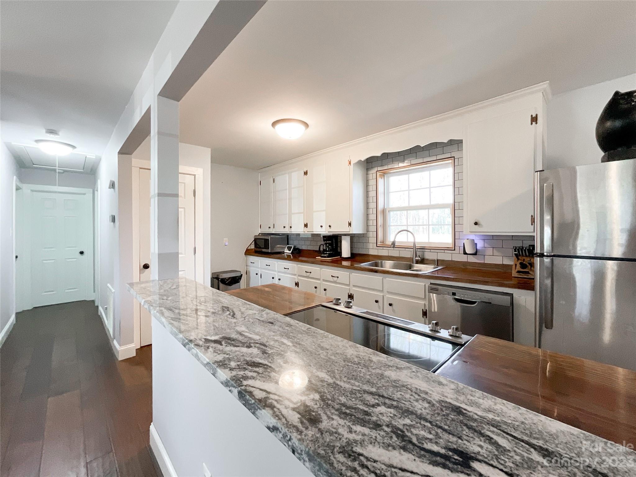 4423 Austin Road Monroe, NC 28112 - Photo 10 of 31 a kitchen with stainless steel appliances granite countertop a refrigerator a sink dishwasher a stove and white countertops with wooden floor