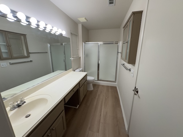 109 Plover Pass Georgetown, TX 78633 - Photo 14 of 25 Bathroom featuring a stall shower, vanity, and dark wood finished floors