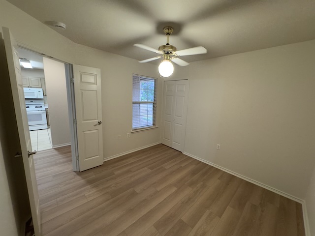 109 Plover Pass Georgetown, TX 78633 - Photo 16 of 25 Unfurnished bedroom featuring wood finished floors, a ceiling fan, and a closet