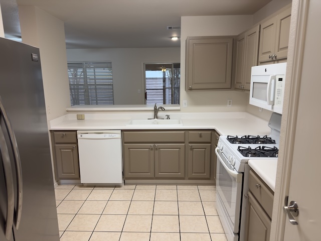 109 Plover Pass Georgetown, TX 78633 - Photo 23 of 25 Kitchen with gray cabinets, white appliances, light countertops, and light tile patterned flooring