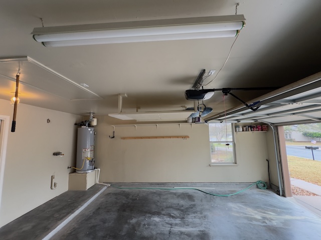 109 Plover Pass Georgetown, TX 78633 - Photo 5 of 25 Garage with water heater and a garage door opener