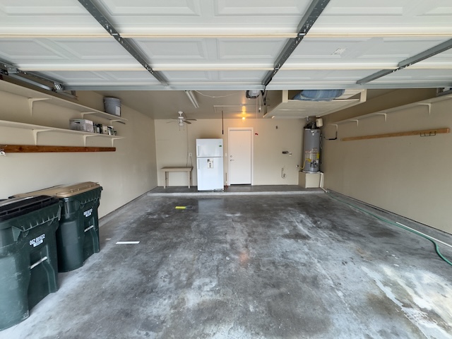 109 Plover Pass Georgetown, TX 78633 - Photo 6 of 25 Garage featuring freestanding refrigerator and water heater