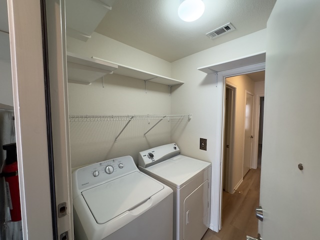 109 Plover Pass Georgetown, TX 78633 - Photo 7 of 25 Laundry area with independent washer and dryer and light wood-style flooring