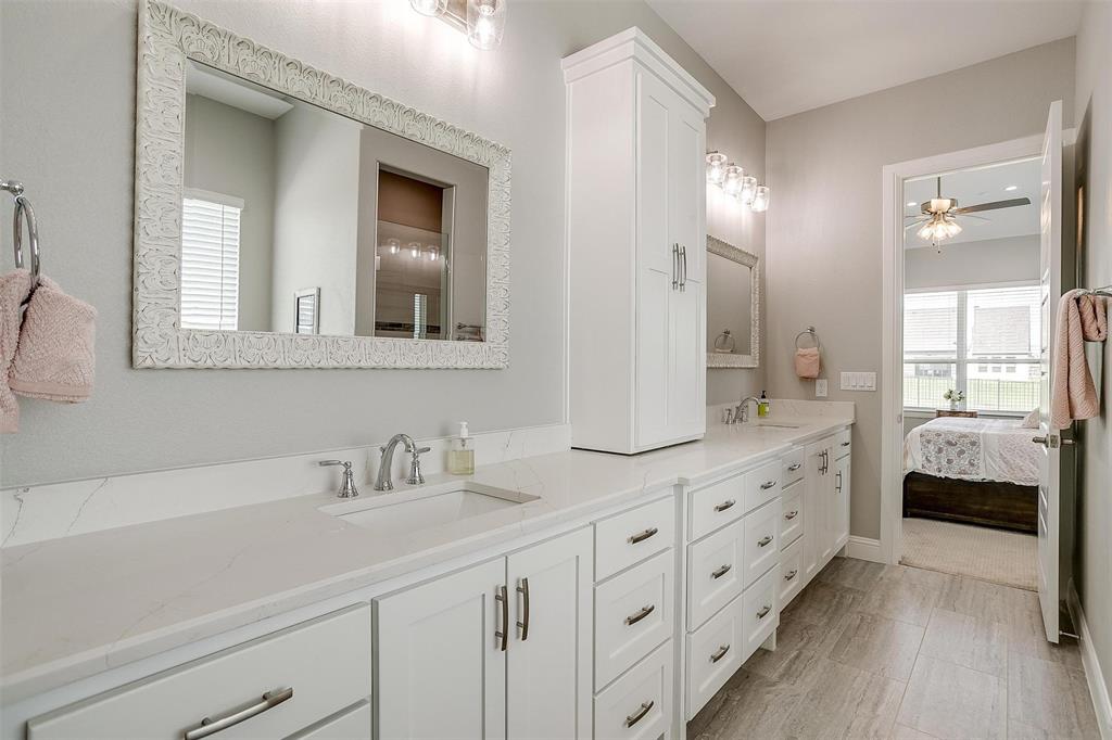 7730 Barber Rnch Road Fort Worth, TX 76126 - Photo 18 of 19 Dual vanity featuring white cabinetry, integrated sinks, chrome fixtures, and a white countertop