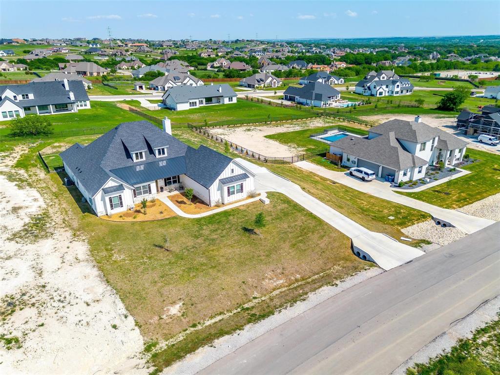 7730 Barber Rnch Road Fort Worth, TX 76126 - Photo 2 of 19 Modern farmhouse-style home featuring white vertical siding, a dark pitched roof with dormer windows, and a paved driveway