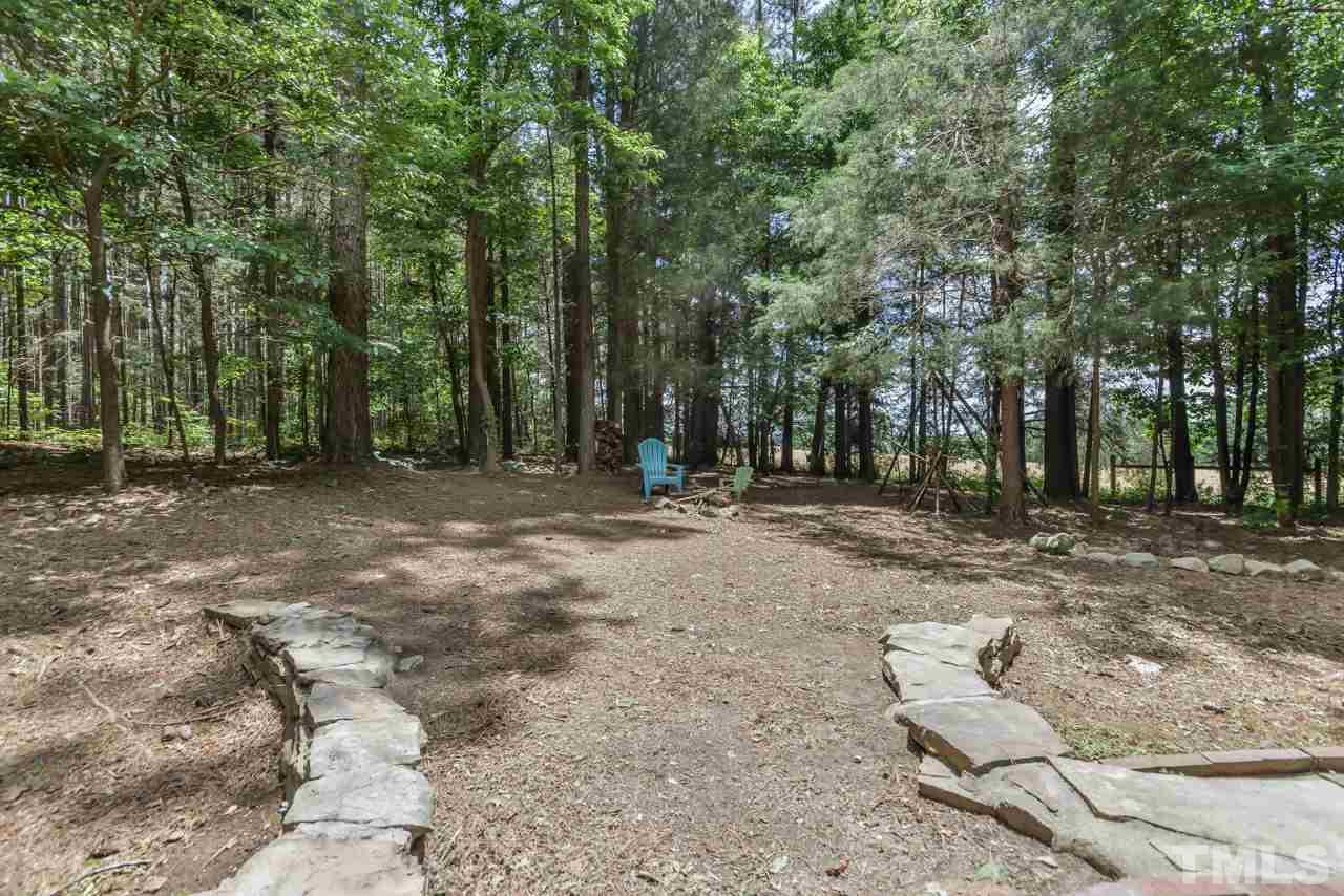 8710 Morrow Mill Road Mebane, NC 27302 - Photo 18 of 24 Path leads from the south side patio over to the fire pit area of the fenced yard.