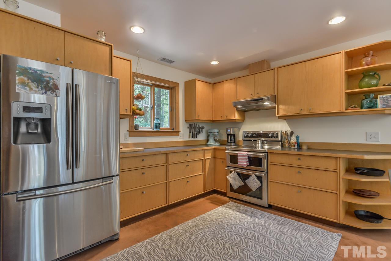 8710 Morrow Mill Road Mebane, NC 27302 - Photo 6 of 24 Great work triangle, plenty of prep space, stainless steel appliances, bar seating and captain's view of the main level of the home.