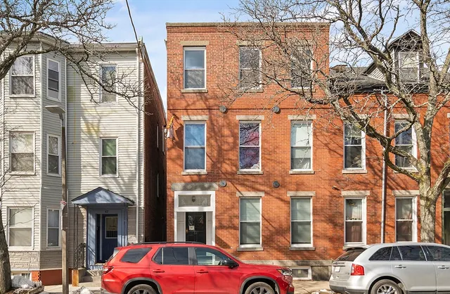 a front view of a building with lot of cars parked