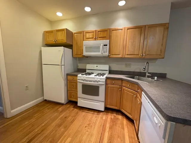 a kitchen with a sink a stove a refrigerator and cabinets