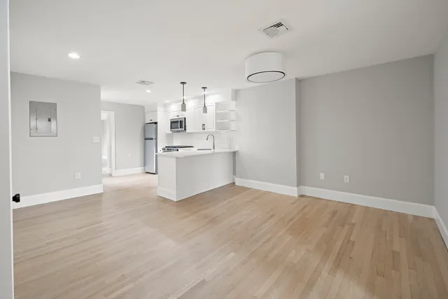 a view of a kitchen with a sink and dishwasher a refrigerator with wooden floor