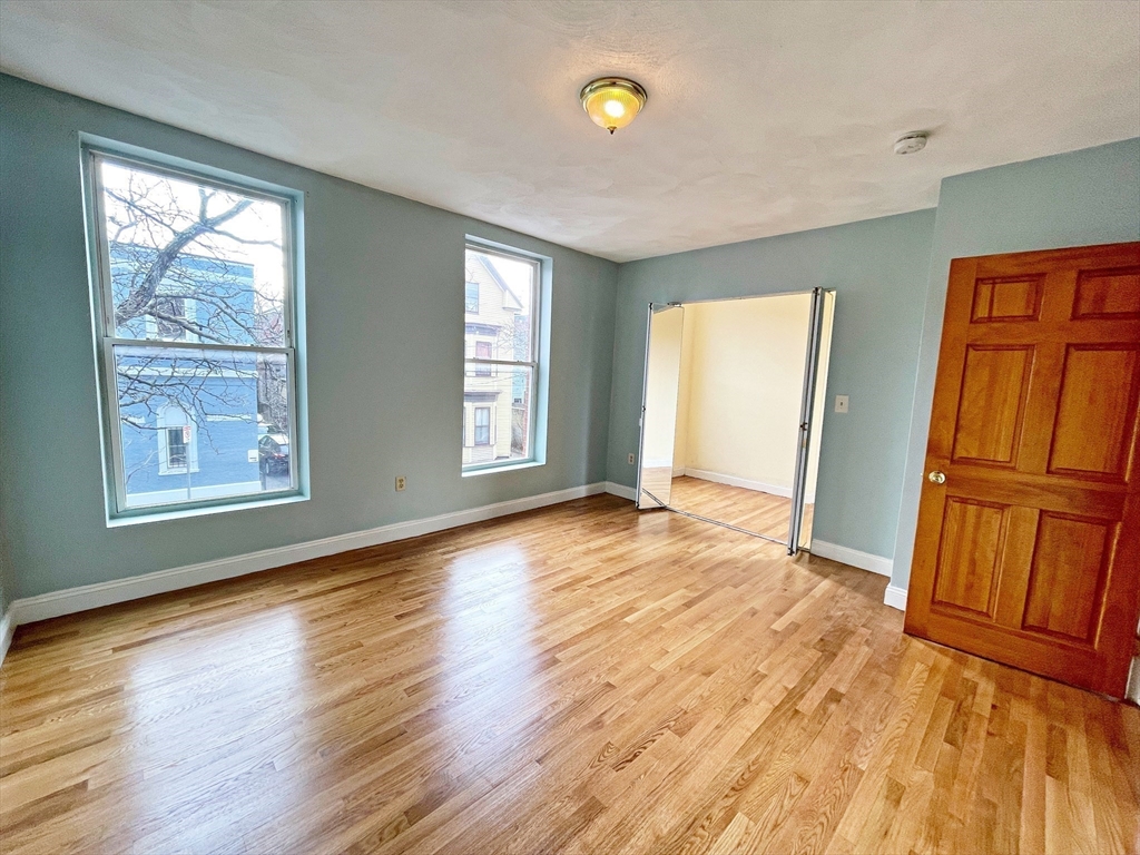 64 Trenton Street Boston, MA 02128 - Photo 21 of 34 a view of an empty room with window and wooden floor