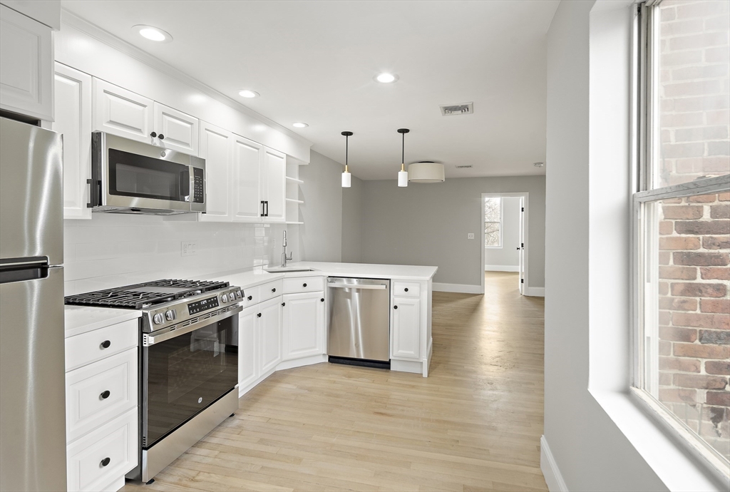 64 Trenton Street Boston, MA 02128 - Photo 8 of 34 a kitchen with stainless steel appliances granite countertop a stove a sink and a microwave